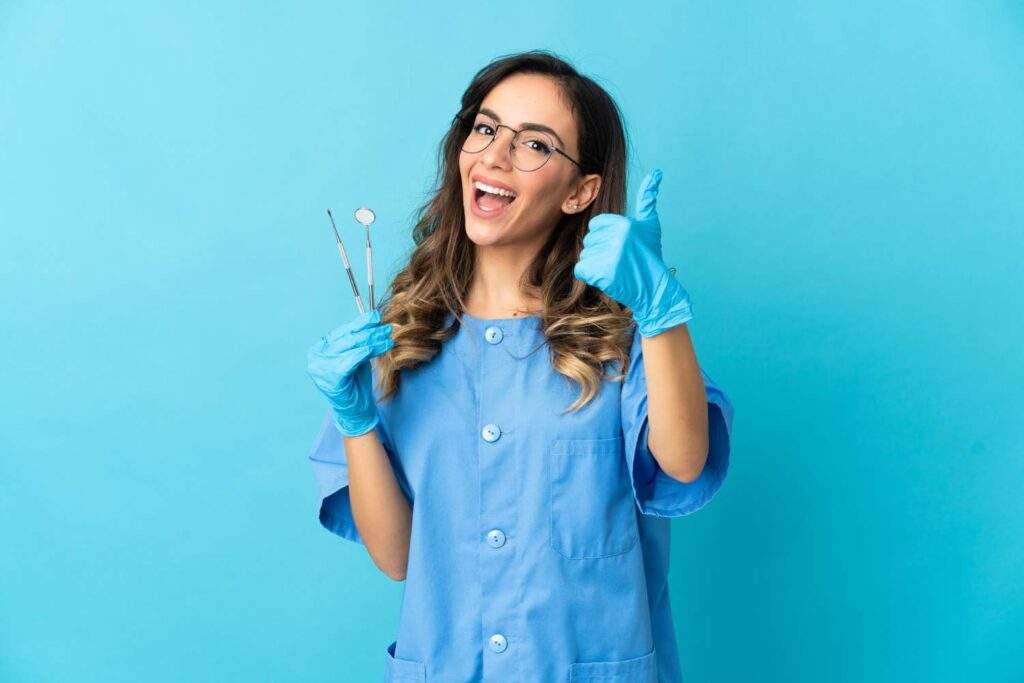 Paciente sonriente con los pulgares hacia arriba tras su visita al dentista